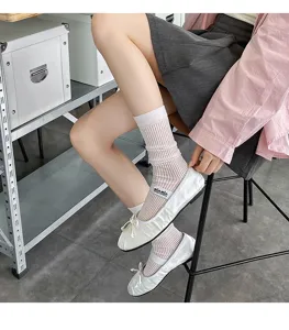Detailed view of women's mid-tube striped slouchy socks paired with stylish ballet flat shoes.