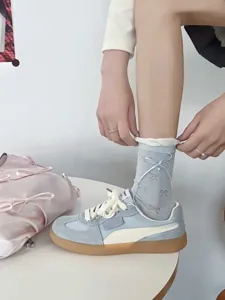 Detail shot of breathable ballet-style bow socks for women, featuring elegant ribbon and pearl accents.