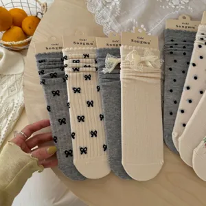 Detail shot of women summer mid-calf socks featuring bows, lace trim and polka dot patterns.