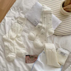 Cream white vintage lace bowknot hollow ribbed mid-calf socks detailed flatlay view
