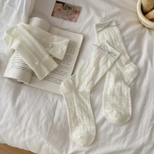 Cream women's mid-calf socks with delicate hollow floral pattern, pearls and grey bows.