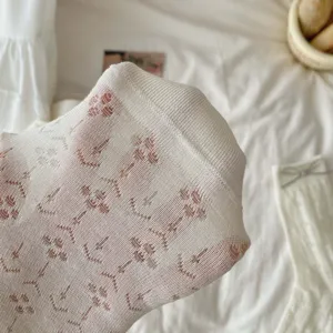 Cream white hollow out floral mid tube socks detail shot, soft breathable summer knit socks.