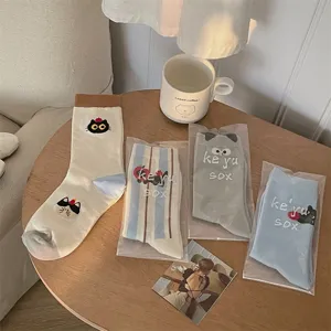 Detailed shot of cute cat and apple print mid-calf socks with striped pattern display.