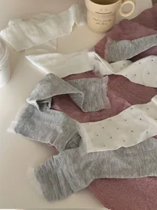 Detailed view of cute Korean style mid-tube socks with lace trim and polka dot patterns.