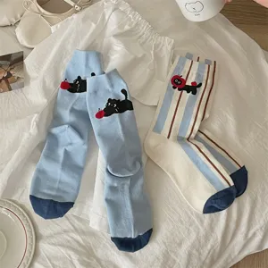 Detail shot of cute cartoon cat and apple embroidered socks with vertical stripes design.