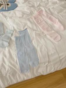 Detailed shot of breathable mesh summer mid-tube socks in pastel blue, pink, and white colors.