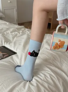 Women cute light blue mid-tube socks featuring black cat and apple knit design, college style.