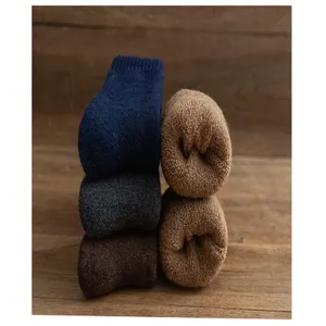 Detailaufnahme dicker, warmer Winter-Wollsocken, ordentlich gestapelt mit weichem Frottee.