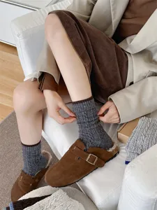 Thick wool knit mid-tube socks detail, warm speckled yarn winter wear, cozy lifestyle closeup.