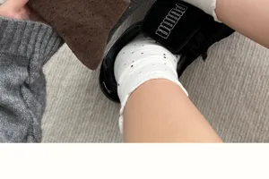 Detailaufnahme von Damen gepunkteten Rüschen-Wadenbaumwollsocken, kombiniert mit Schuhen.