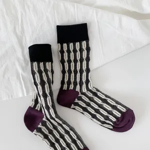 Detailed close-up of retro contrast color twist knit mid-tube socks with cozy cotton fabric texture.