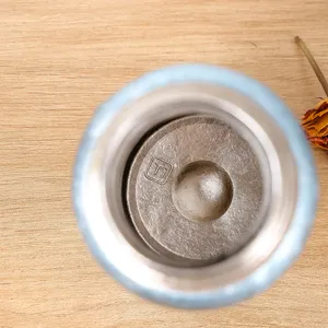 Vue de détail intérieur d'une tasse isolée en pur titane avec un beau travail artisanal.