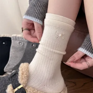Detailed shot of Korean style women cashmere socks featuring pearl bow embroidery and ribbed cuff.