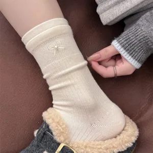 Cozy knit mid-calf socks with cute pearl bow detail, soft cashmere blend, stylish winter wear.