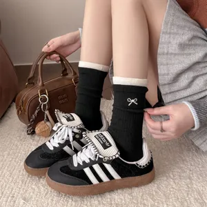 Korean style black cashmere mid-tube socks with contrast white trim and elegant pearl bow detail.