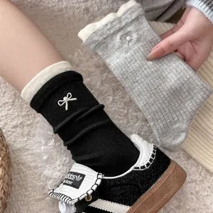 Close-up detail of cozy women winter mid-tube socks with cute pearl bow embroidery.