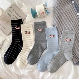 Detailed view of cute striped mid-tube socks featuring adorable embroidered dachshund patterns.