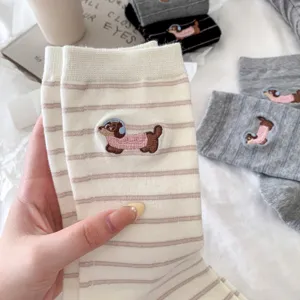 Detailed shot of cute embroidered dachshund socks featuring fine stripes and soft cotton fabric.