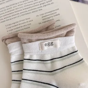 Detailopname van gestreepte katoenen sokken met een klein label op een open receptenboek.