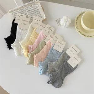 Detailed view of multi-color cotton frilly socks neatly displayed with lifestyle props.
