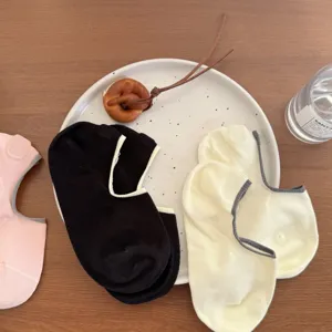 Detail shot of women's low-cut invisible socks in multiple colors presented on a white ceramic plate.
