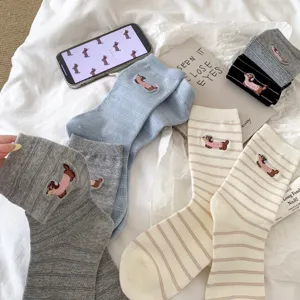 Detailed view of cute embroidered dachshund cotton mid-calf socks with fine striped pattern.