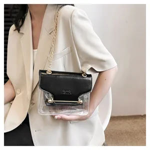 Detail shot of clear transparent cross-body bag with contrasting black flap and chic chain.