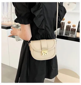 Chic beige leather saddle bag for women, featuring a metal clasp and sleek crossbody strap.