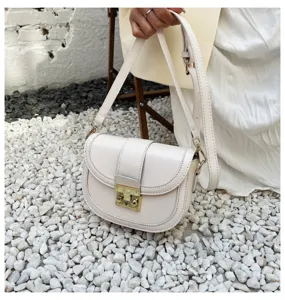 Women's stylish white PU leather saddle bag with gold hardware, elegant crossbody bag.
