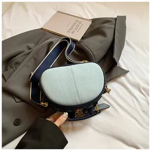 Detailansicht der stylischen Jeans Patchwork Umhängetasche mit breitem Gurt und Metallbeschlägen.