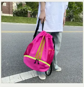 Detailaufnahme des knallpinkingen Kordelzug-Sportrucksacks mit grünen Streifen und Bodenfach.