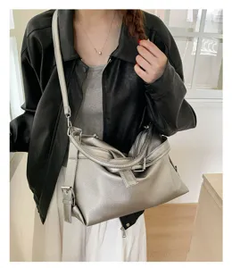 Close-up detail of silver metallic motorcycle shoulder bag, unique knot and strap.