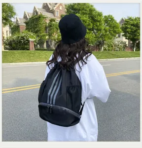 Detailansicht des schwarzen Kordelzug-Rucksacks mit reflektierenden Streifen vom Model.