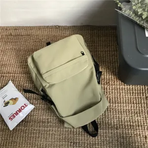 Minimalistischer salbeigrüner Nylon-Rucksack mit Fronttasche und Seitenriemen, Detailansicht.