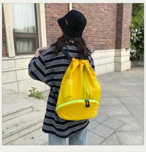 Nahaufnahme eines hellgelben Turnbeutels mit grünen Streifen und praktischen Taschen.