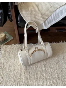 White leather cylindrical barrel handbag with vintage kiss lock closure and double top handles.