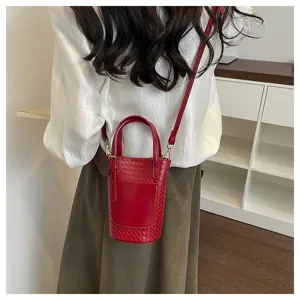 Red woven bucket bag for women, stylish leather shoulder bag with top handle and crossbody strap.