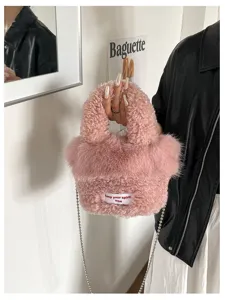 Detail shot of fluffy plush crossbody bag in pink with chain strap and cute woven label.