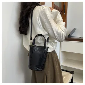 Elegant black woven bucket bag for women, stylish leather shoulder handbag for daily use.