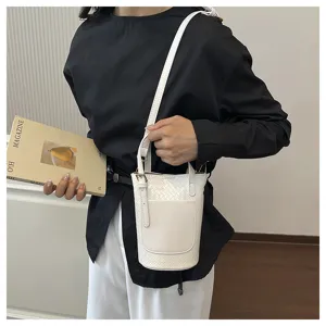 Detailed view of white woven bucket shoulder bag, premium leather texture, chic design.