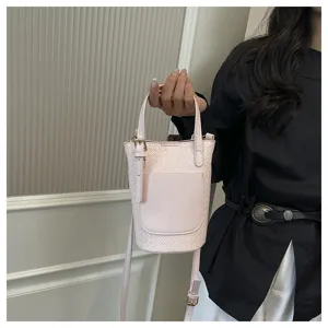 Pink woven bucket bag detail shot, stylish shoulder handbag with top handle and front pocket.
