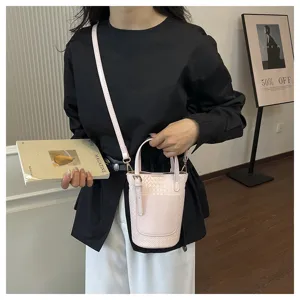 Pink woven bucket bag detail showcasing texture, leather strap, and stylish shoulder design.