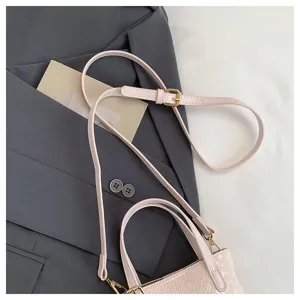 Pink woven leather handbag detail shot, featuring delicate strap and metallic buckle design.