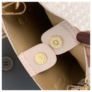 Close-up detail view of women's woven bucket handbag interior magnetic snap hardware.