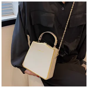 Elegant beige structured box handbag with chic gold metal frame and stylish chain strap detail.