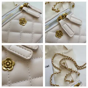 Quilted chain mini bag details showing camellia flower charm and gold hardware strap.