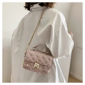 Close-up detail of stylish pink quilted chain cross-body bag worn by model, chic look.