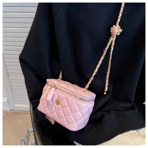Pink quilted vanity crossbody bag detail, chic diamond pattern with golden chain and zipper.