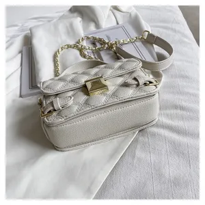 Detailed shot of a stylish white quilted leather crossbody bag with a luxury gold chain strap.