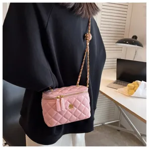 Detailed shot of pink quilted box bag with chain strap, showing elegant metal flower accent.